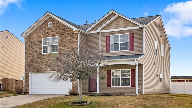 view of front of house with a front yard, fence, a garage, stone siding, and driveway