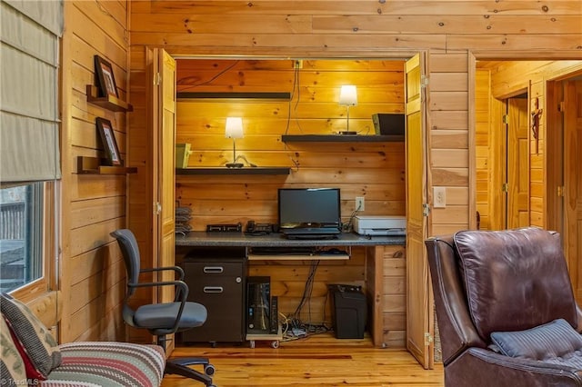 office area featuring built in desk and wood walls