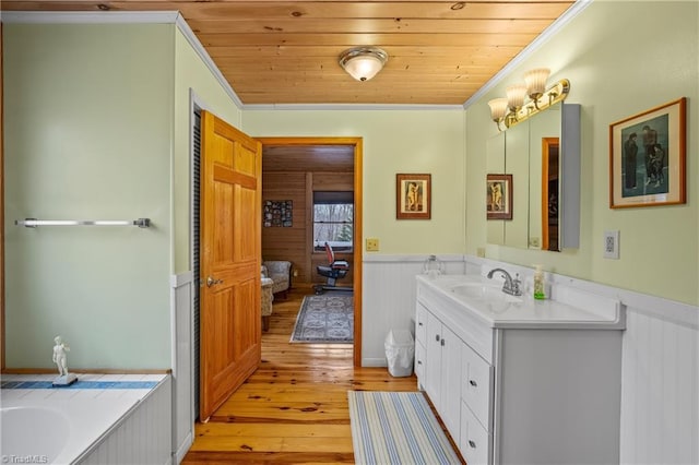 bathroom featuring a washtub, wood ceiling, vanity, wood-type flooring, and ornamental molding