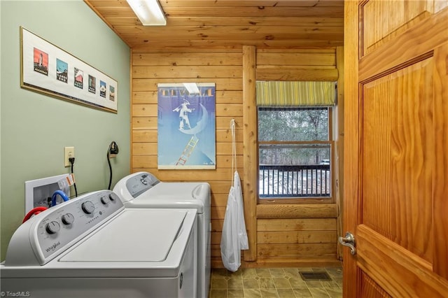 laundry room with wooden walls, washing machine and clothes dryer, and wood ceiling