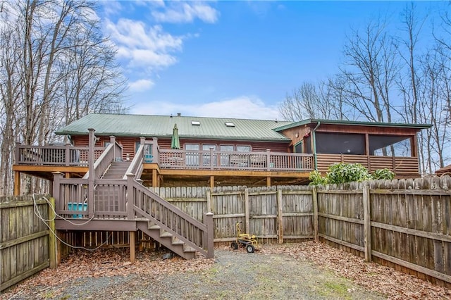 rear view of property with a deck and a sunroom