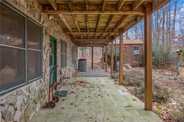 view of patio with central AC and a shed