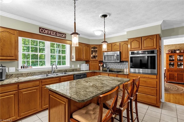 4717 Deaton Rd, Trinity, NC 27370 - kitchen with appliances with stainless steel finishes, brown cabinets, light tile patterned floors, a center island, and a kitchen bar
