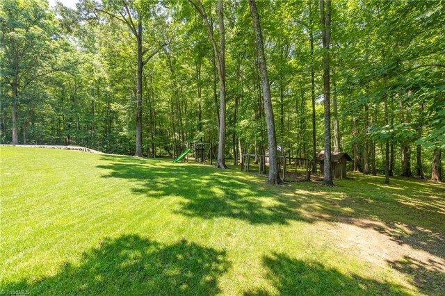 4717 Deaton Rd, Trinity, NC 27370 - view of grassy yard with a playground and a forest view