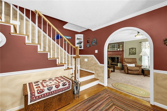 4717 Deaton Rd, Trinity, NC 27370 - stairway with arched walkways, wood finished floors, a brick fireplace, ornamental molding, and a wainscoted wall