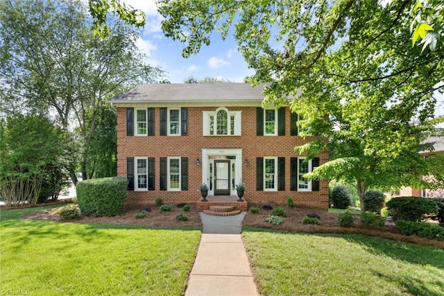 colonial-style house with a front yard and brick siding
