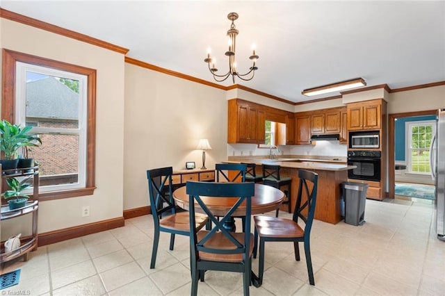 dining area featuring a chandelier, baseboards, and crown molding