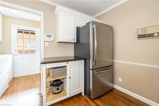 2014 Medhurst Dr, Greensboro, NC 27410 - kitchen with freestanding refrigerator, wood finished floors, white cabinetry, ornamental molding, and a wainscoted wall
