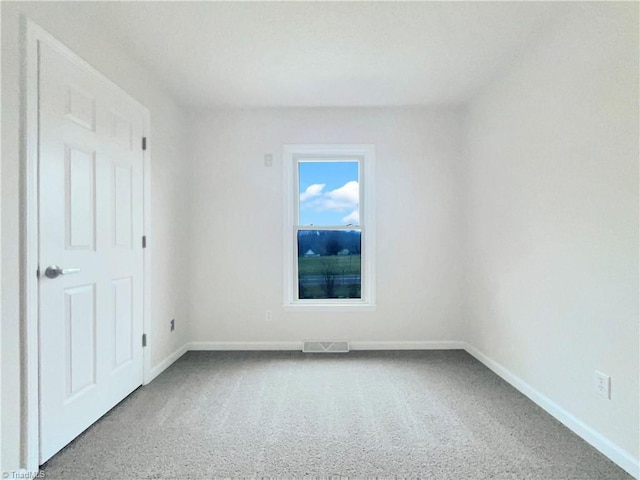 carpeted empty room featuring visible vents and baseboards