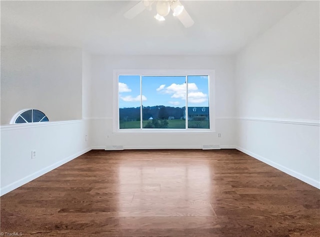 unfurnished room featuring ceiling fan, dark wood finished floors, and baseboards