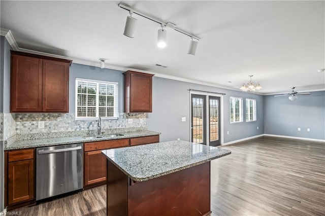 kitchen with stainless steel dishwasher, ornamental molding, and a sink