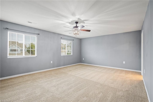 empty room with a ceiling fan, baseboards, visible vents, and carpet floors