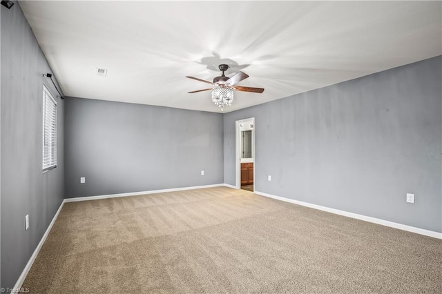 carpeted empty room featuring visible vents, baseboards, and ceiling fan