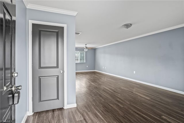 unfurnished room with crown molding, baseboards, and wood finished floors