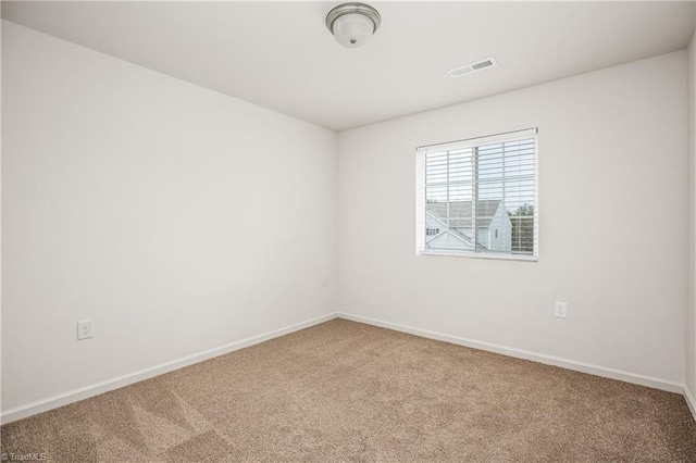 empty room featuring baseboards, visible vents, and carpet floors