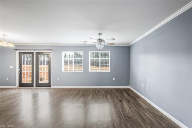 empty room featuring baseboards, a healthy amount of sunlight, wood finished floors, and ornamental molding