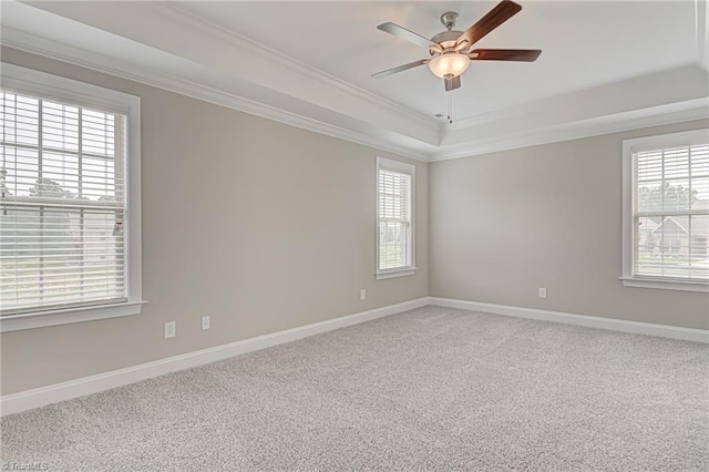 unfurnished room with a tray ceiling, carpet flooring, ornamental molding, and ceiling fan