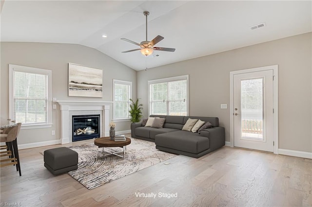 living room featuring ceiling fan, light wood-type flooring, plenty of natural light, and vaulted ceiling