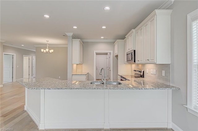 kitchen featuring white cabinetry, light stone counters, kitchen peninsula, stainless steel appliances, and sink