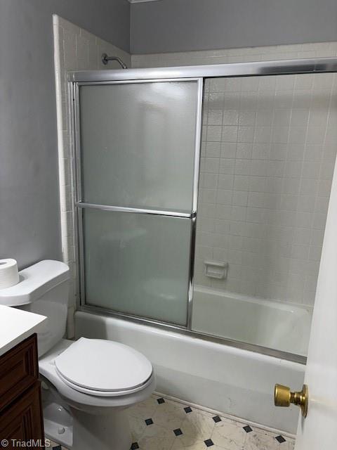 full bathroom featuring enclosed tub / shower combo, vanity, and toilet