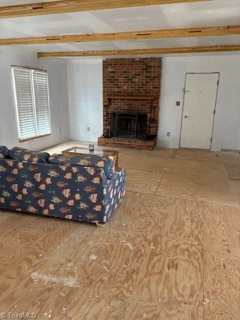 unfurnished living room featuring beamed ceiling and a fireplace