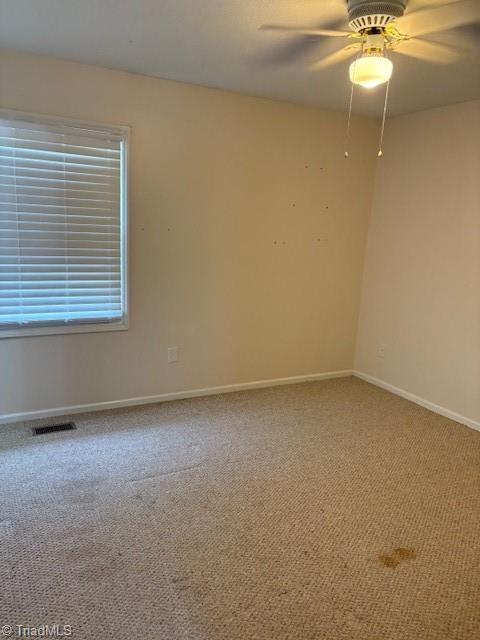 carpeted spare room featuring ceiling fan