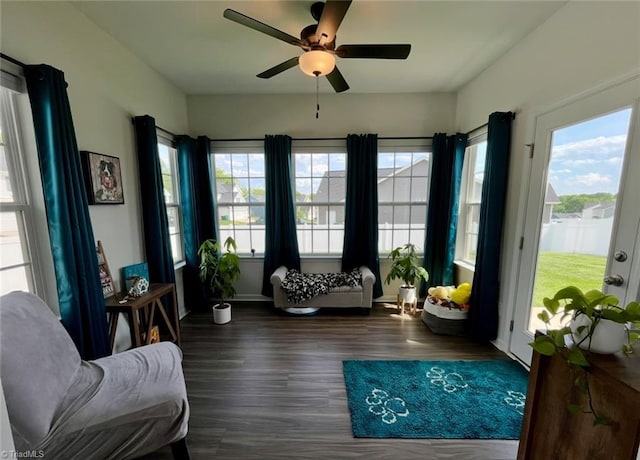 sitting room featuring baseboards, a ceiling fan, and dark wood-style flooring