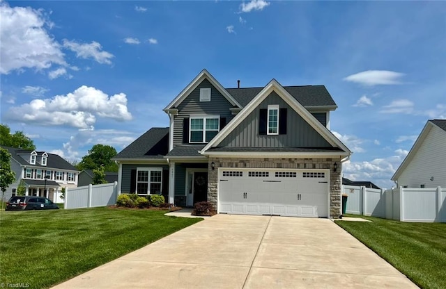 craftsman inspired home with board and batten siding, fence, and a front lawn