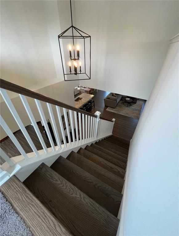 staircase featuring an inviting chandelier