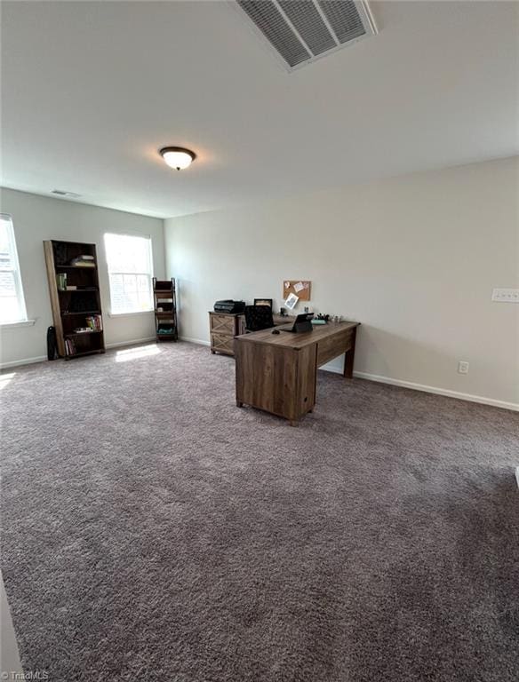 carpeted office space featuring baseboards and visible vents