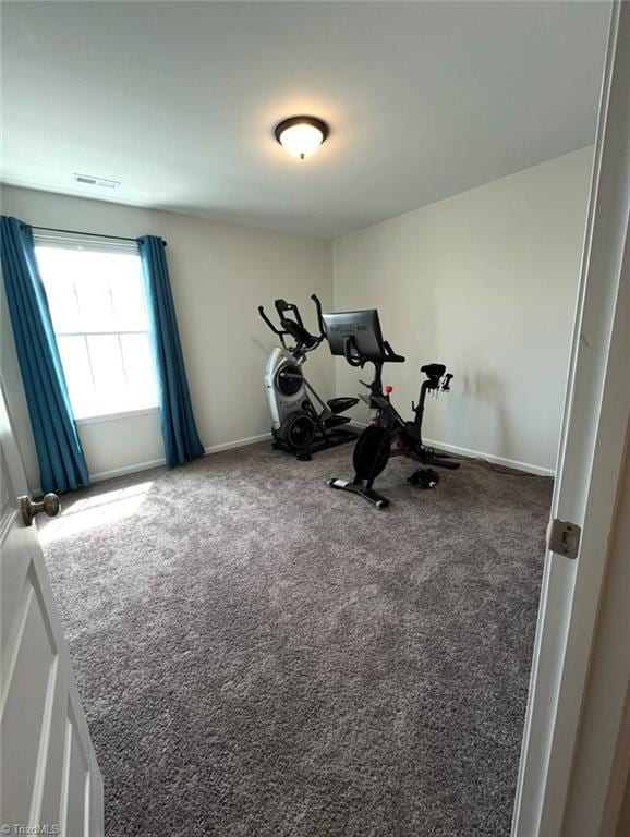 exercise room with visible vents, carpet, and baseboards