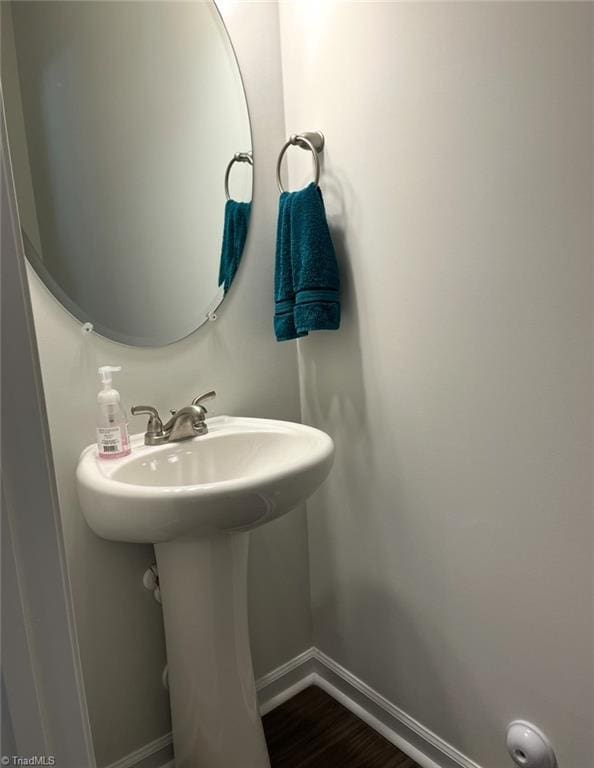 bathroom with baseboards and wood finished floors