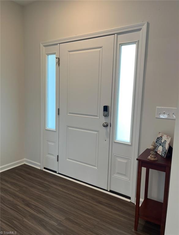foyer entrance featuring dark wood-style flooring and baseboards