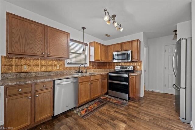1310 Silver Dr, Mebane, NC 27302 - kitchen with appliances with stainless steel finishes, a sink, backsplash, and brown cabinets