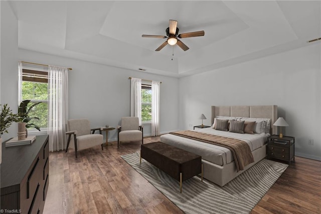 1310 Silver Dr, Mebane, NC 27302 - bedroom featuring a tray ceiling, wood finished floors, a ceiling fan, and baseboards