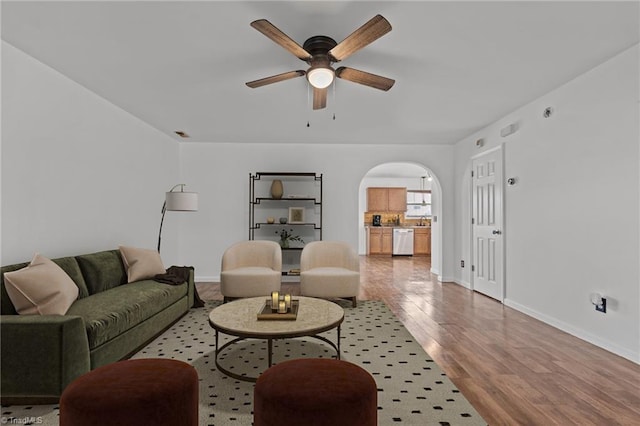 1310 Silver Dr, Mebane, NC 27302 - living room featuring a ceiling fan, arched walkways, wood finished floors, and baseboards