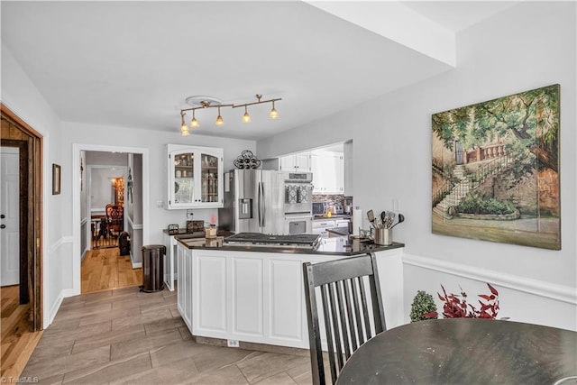 408 Camelot Dr, Salisbury, NC 28144 - kitchen with stainless steel appliances, dark countertops, white cabinets, glass insert cabinets, and a peninsula