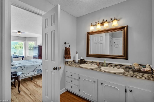 408 Camelot Dr, Salisbury, NC 28144 - ensuite bathroom with a textured ceiling, double vanity, wood finished floors, and a ceiling fan