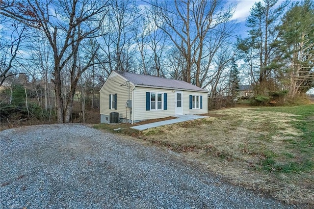 view of front of house featuring a front lawn and central AC