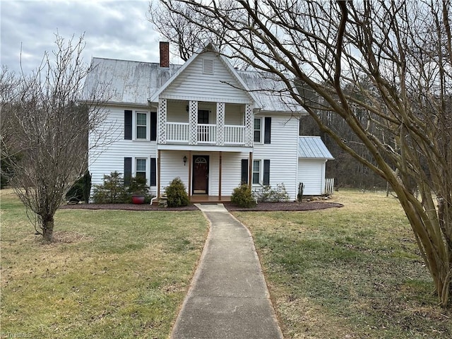 view of front facade with a front yard, a balcony, and a porch