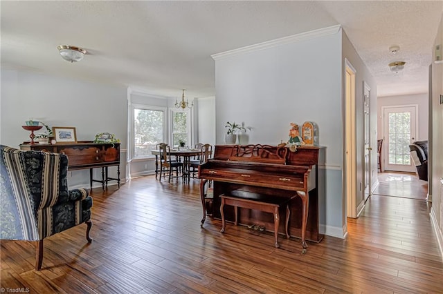 miscellaneous room with crown molding, wood-type flooring, and an inviting chandelier