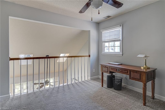 carpeted office featuring ceiling fan and a textured ceiling