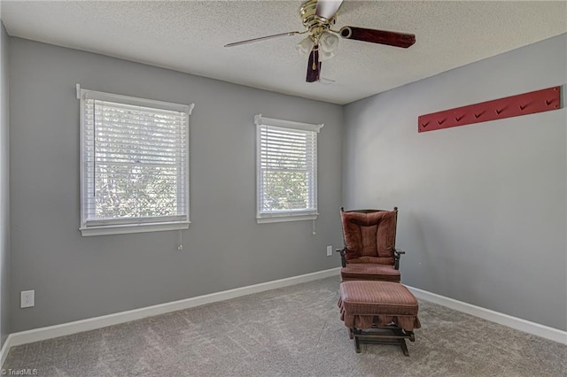 living area featuring light carpet, a textured ceiling, and ceiling fan