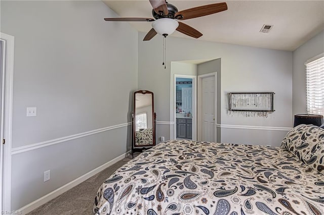 carpeted bedroom with ceiling fan, lofted ceiling, and ensuite bath