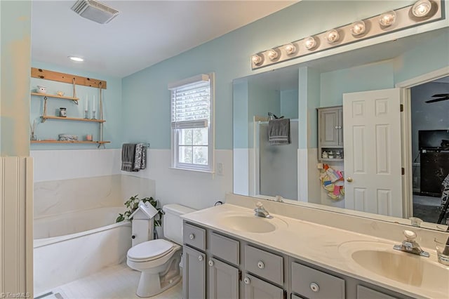 bathroom featuring toilet, vanity, tile patterned floors, and a bath