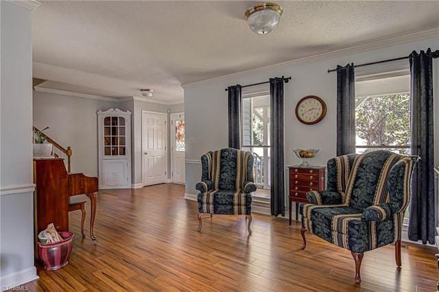 living area featuring hardwood / wood-style floors, crown molding, and a textured ceiling