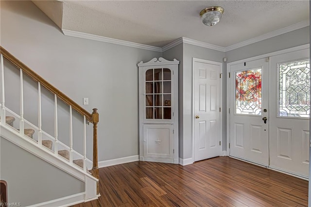 foyer featuring dark wood-type flooring, crown molding, and a textured ceiling