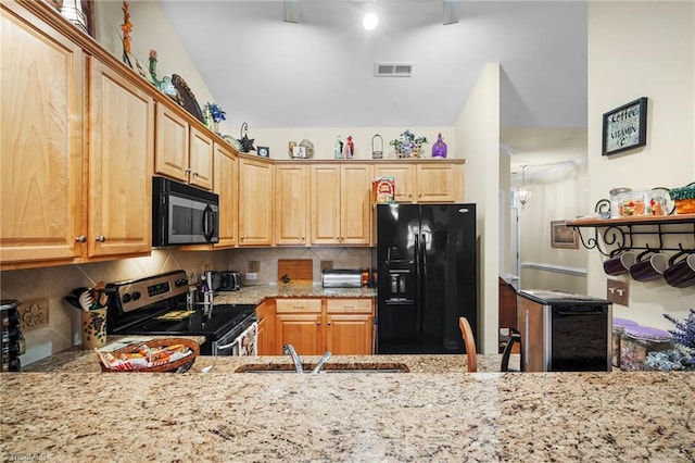 kitchen with light stone countertops, visible vents, a sink, decorative backsplash, and black appliances