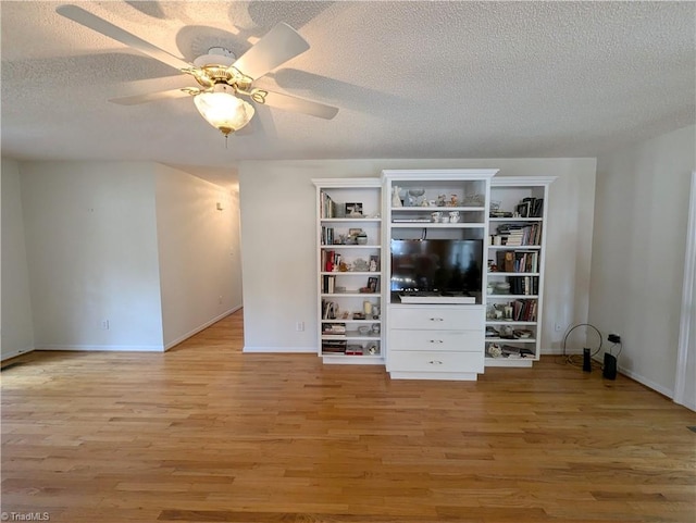 unfurnished living room featuring ceiling fan, a textured ceiling, and light wood-type flooring