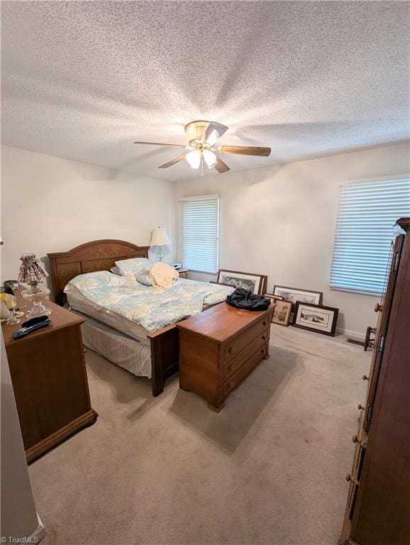 carpeted bedroom with a textured ceiling and ceiling fan